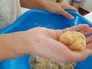 Image: Hand holding ball of sweet potato biscuit dough